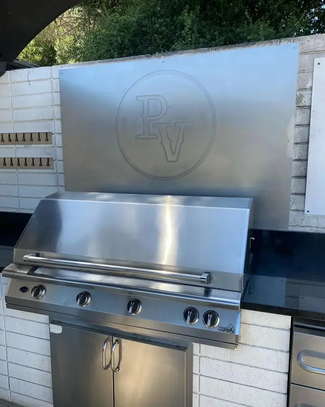 Stainless grill set under a medallion-patterned backsplash